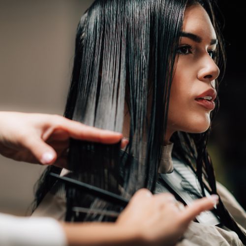 A woman getting her hair cut by a hair stylist