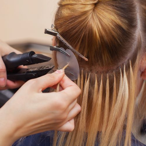 A woman cutting another woman's hair with scissors