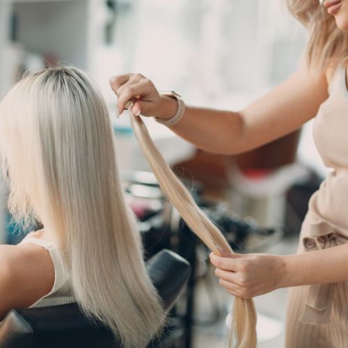 A woman cutting another woman's hair in a salon